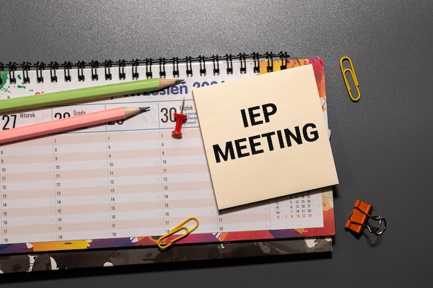 Texto de la reunión IEP en un cuaderno con ratón y bolígrafo para portátil