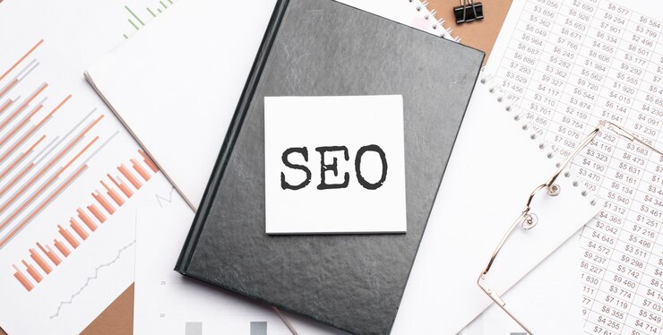 Texto SEO en el bloc de notas con herramientas de oficina, lápiz en el informe financiero.