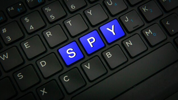 Foto texto spy de primer plano en el botón clave con color azul en un fondo de teclado de portátil negro clave de seguridad contra hackers y espías en línea concepto de protección tecnológica foco selectivo