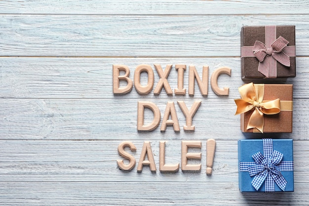 Texto venta del día de boxeo y cajas de regalo sobre fondo de madera