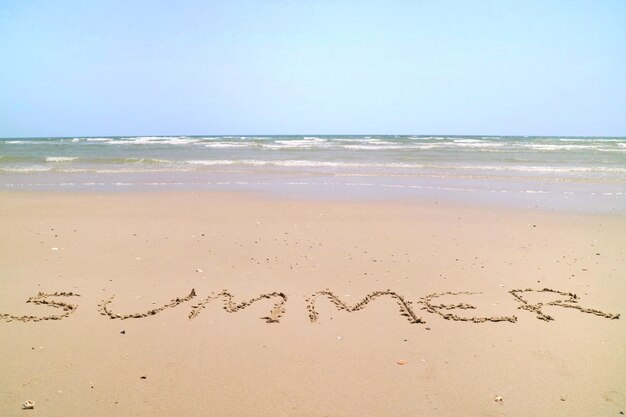 Texto VERANO con las olas en la playa y el cielo azul en la mañana de verano Concepto de naturaleza y vacaciones