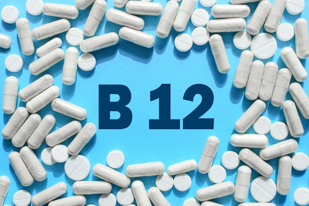 Foto texto de vitamina b12 en cápsulas blancas enmarcadas en un fondo azul píldora con cobalamina