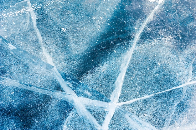 Textur aus blauem Eis mit Rissen und Luftblasen auf dem zugefrorenen See. Makrobild. Winter Natur Hintergrund