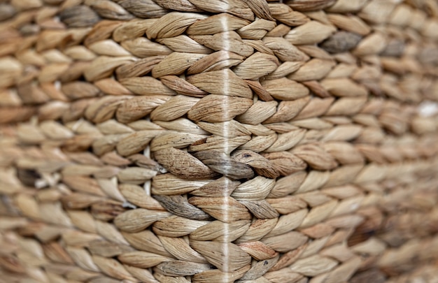 Textur aus gewebtem beigefarbenem Stroh, Hintergrund von Zöpfen aus der Nahaufnahme des Pflanzenstamms.