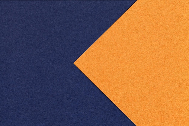 Textur aus marineblauem und orangefarbenem Papierhintergrund, halb zwei Farben mit Pfeilmakro Struktur aus dichtem Bastelkarton