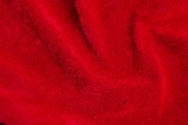Textur aus rotem Samtstoff, der als Hintergrund verwendet wird. Roter Stoffhintergrund aus weichem und glattem Textilmaterial. Es gibt Platz für Text x9