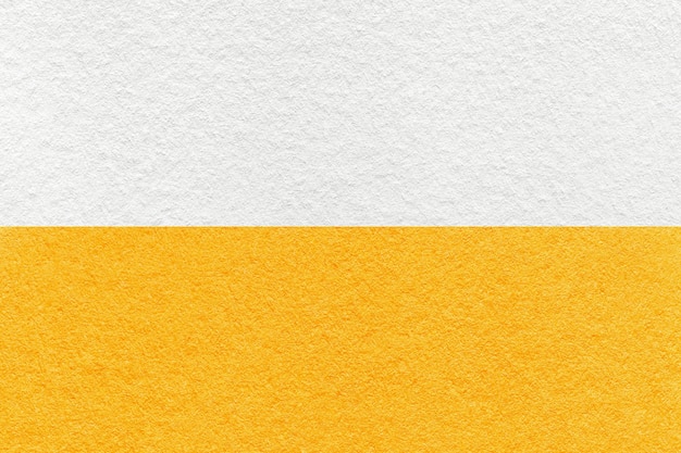 Textur aus weißem und hellgelbem Papierhintergrund halb zwei Farben Makro Vintage dichter orangefarbener Karton