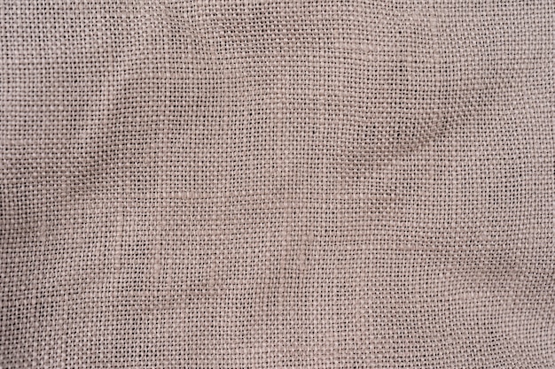 Textur beige Baumwolle Textil Hintergrund detaillierte Nahaufnahme, rustikale zerknitterte strukturierte Stoff Sackleinen