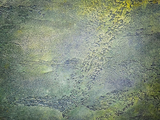 Textur der alten Mauer mit dekorativen Putzfarben in Marineblau und Grün. Beschmutzter Beton verwitterte olivgrüner Hintergrund des Schmutzes mit Vignette. Abstrakte Steinstuckoberfläche, Nahaufnahme.