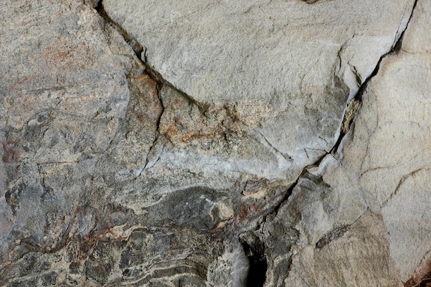 Textur der alten Steinfelsen verwitterte Oberfläche Naturdetail der Felsen Closeup raue braune Steinmauer