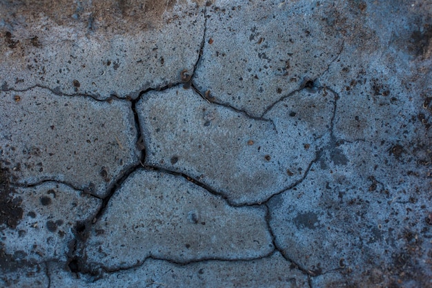 Textur der getrockneten Erde Dunkelgrauer Hintergrund mit Rissen und Vertiefungen Dürre und Feuchtigkeitsmangel im Boden Die Folgen abnormaler Hitze Umweltkatastrophe Globale Erwärmung