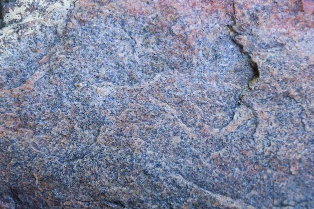 Textur des Granits aus der Nähe Granitgestein mit rötlicher Farbe Hintergrund aus massivem Stein