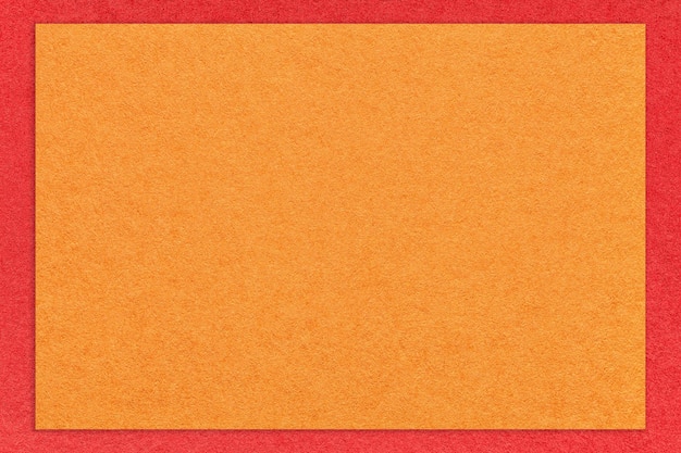 Textur des Handwerks leuchtend orangefarbener Papierhintergrund mit rotem Randmakro Vintage dichter Kraft-Ingwer-Karton