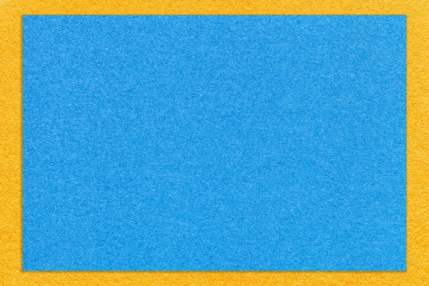 Textur des hellblauen Papierhintergrunds mit gelbem Randmakro Struktur aus Vintage-Karton