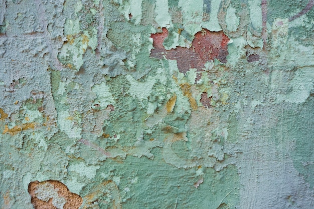 Textur einer alten Mauer mit grünlich abblätternder Farbe