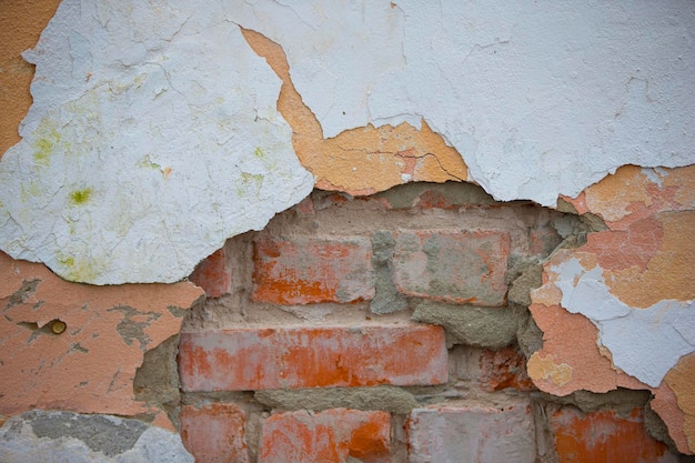 Textur einer alten Ziegelsteinmauer mit schälender weißer Farbe