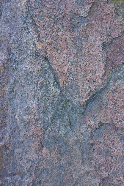 Textur von Granit aus der Nähe Granitgestein mit rötlicher Farbe Hintergrund aus massivem Stein