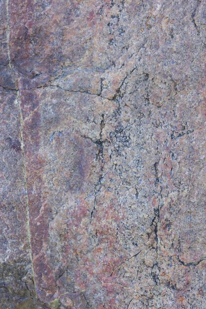 Textur von Granit aus der Nähe Granitgestein mit rötlicher Farbe Hintergrund aus massivem Stein