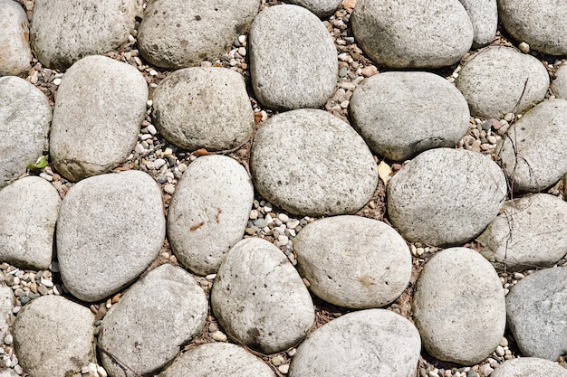 Textur von großen glatten Steinen, die dekorativ auf dem Boden ausgelegt sind. Landschaftsdesign-Fragment. Abstrakter Hintergrund.
