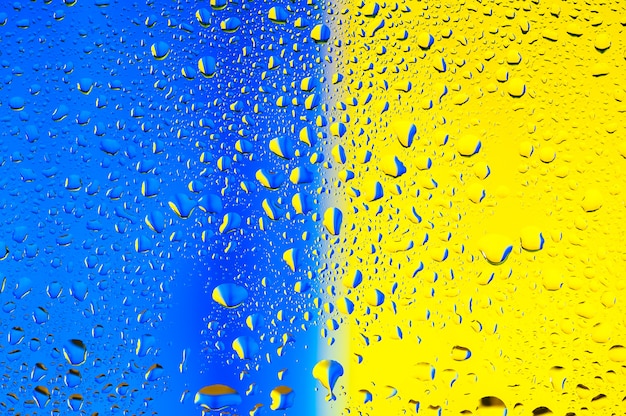 Textura abstracta Gotas de agua sobre vidrio con azul y amarillo.