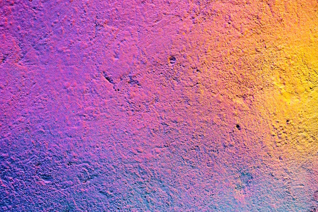 Textura abstracta de metal con una lata de aerosol de pintura un degradado de amarillo, morado y rosa.