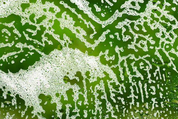 Foto textura abstrata verde brilhante com padrão de espuma de sabão em vidro