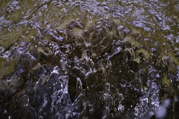 Textura del agua en estado natural en un río al salpicar contra las piedras