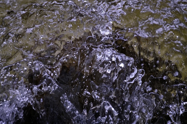 Textura del agua en estado natural en un río al salpicar contra las piedras