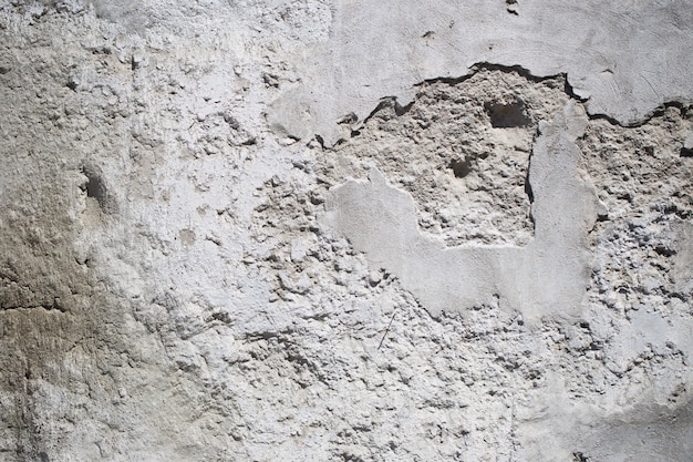 Textura de un antiguo muro de hormigón blanco con pequeños agujeros