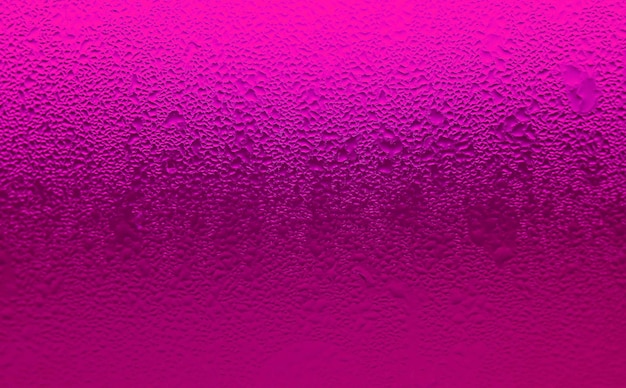 Textura aproximada de gotas de água no copo de coquetel gelado rosa quente