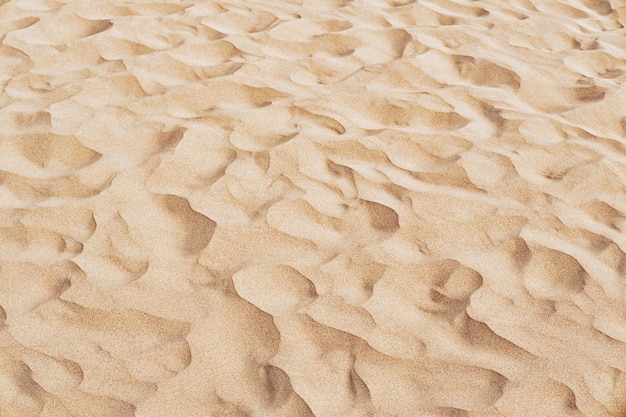 Foto textura de arena natural arena amarilla en la playa fondo de arena ondulado para diseños de verano