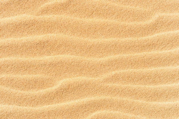 Foto textura de arena en la playa con olas como fondo tropical natural