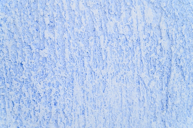 Textura áspera da luz decorativa abstrata - fundo azul da parede do emplastro.