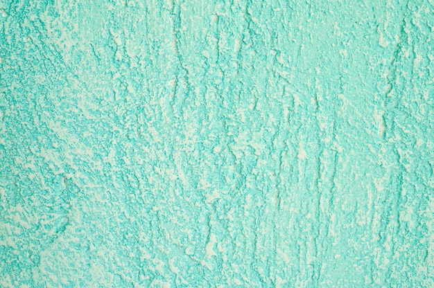 Textura áspera del fondo verde claro decorativo abstracto de la pared del yeso.