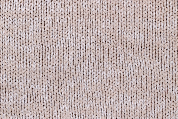 Textura bege de suéter de malha de lã. Tricô à mão.