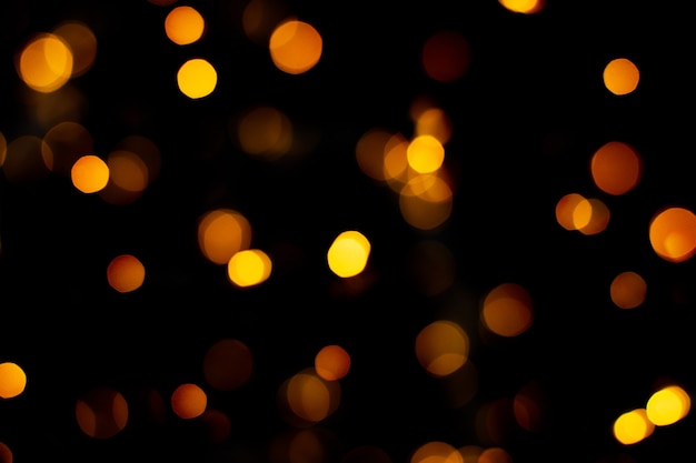 Textura de brillo dorado abstracto borrosa, luces de Navidad desenfocadas en negro