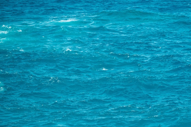 Textura calma da superfície da água do mar com salpicos e ondas abstraem o fundo da natureza do aqua