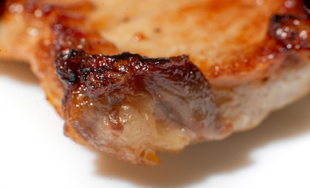 Textura de carne frita de cerca Un trozo graso de cerdo en una gran aproximación Daño de la carne frita en aceite