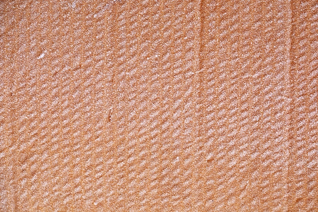 La textura del cartón amarillo húmedo está cubierta de escarcha.