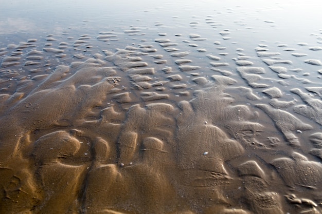 La textura de la costa del mar en la mañana de verano Patrón de arena en la playa durante la marea baja