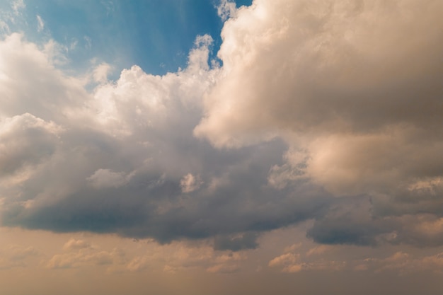 La textura de los cúmulos cálidos dramáticos en el cielo azul frío es una imagen con perspectiva de nubes bajas y nubladas durante la puesta de sol con rayos reflectantes