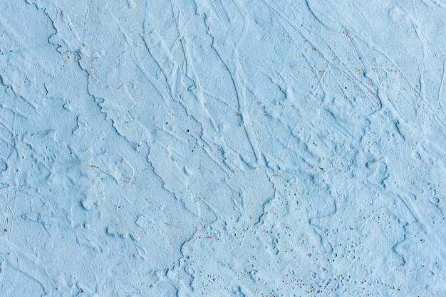 Textura da parede azul clara de concreto parede áspera azul a superfície é pintada com um spray aerossol
