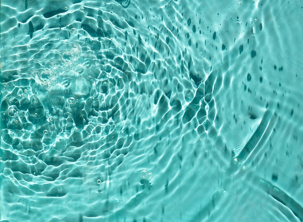 Textura da superfície com salpicos e bolhas. tônico hidratante cosmético de água azul. fundo abstrato da natureza.