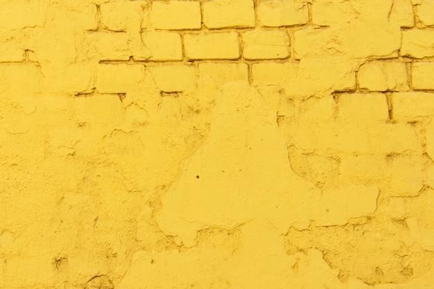 Textura da superfície da parede de tijolo amarelo antigo com costuras de cimento e concreto