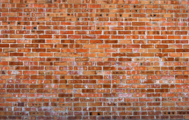 Foto textura da superfície da parede de tijolo vermelho velho com costuras de cimento e concreto