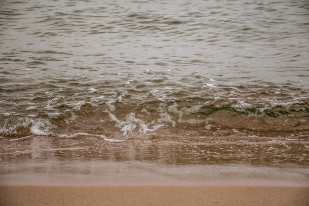 Textura das ondas do mar em cores neutras e quentes para papel de parede, plano de fundo, vídeo ou design.