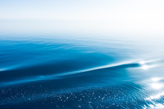 Textura de água clara em azul e laranja Fundo do oceano e do mar iluminado pelo sol Água natural