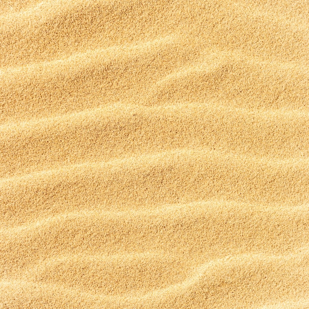 Textura de areia na praia com ondas como pano de fundo tropical natural