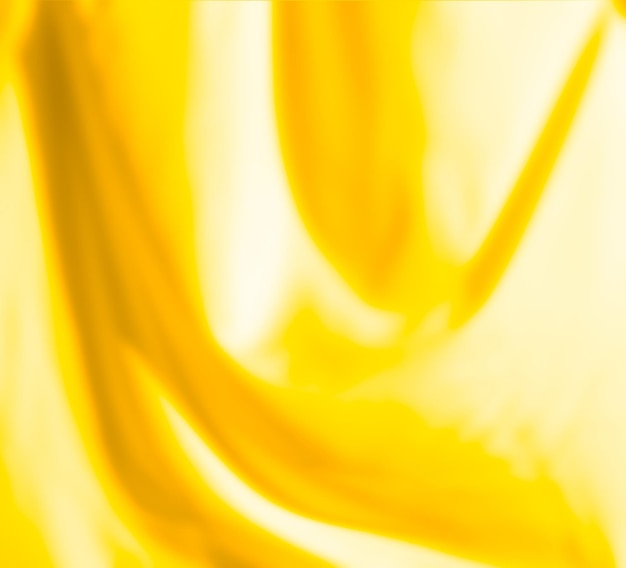 Textura de cetim de seda dourada e borrão. Fundo abstrato artístico desfocado de tecido amarelo dourado