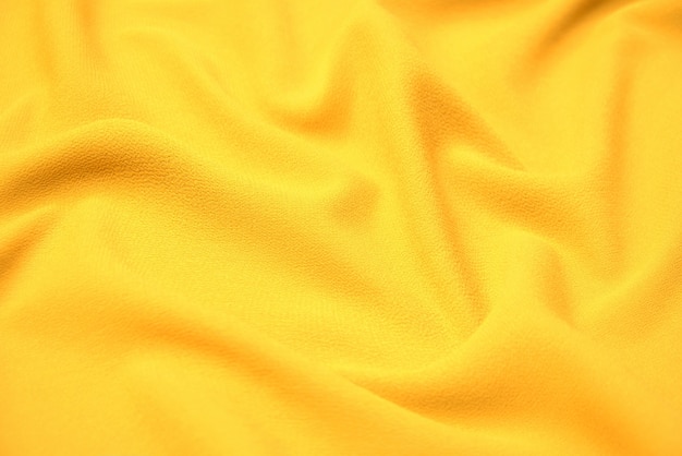 Textura de close-up de tecido laranja ou amarelo natural ou pano da mesma cor. textura de tecido de algodão natural, seda ou lã, ou material têxtil de linho. fundo de tela amarela.